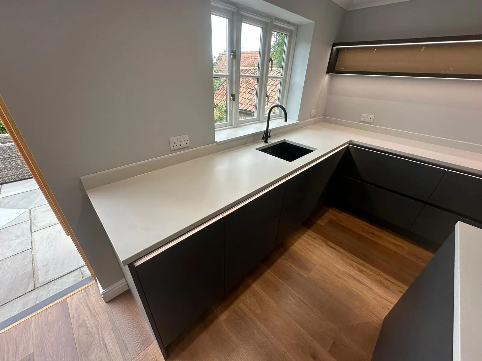 Pale quartz worktop with an undermounted sink and black tap fitted in Colchester
