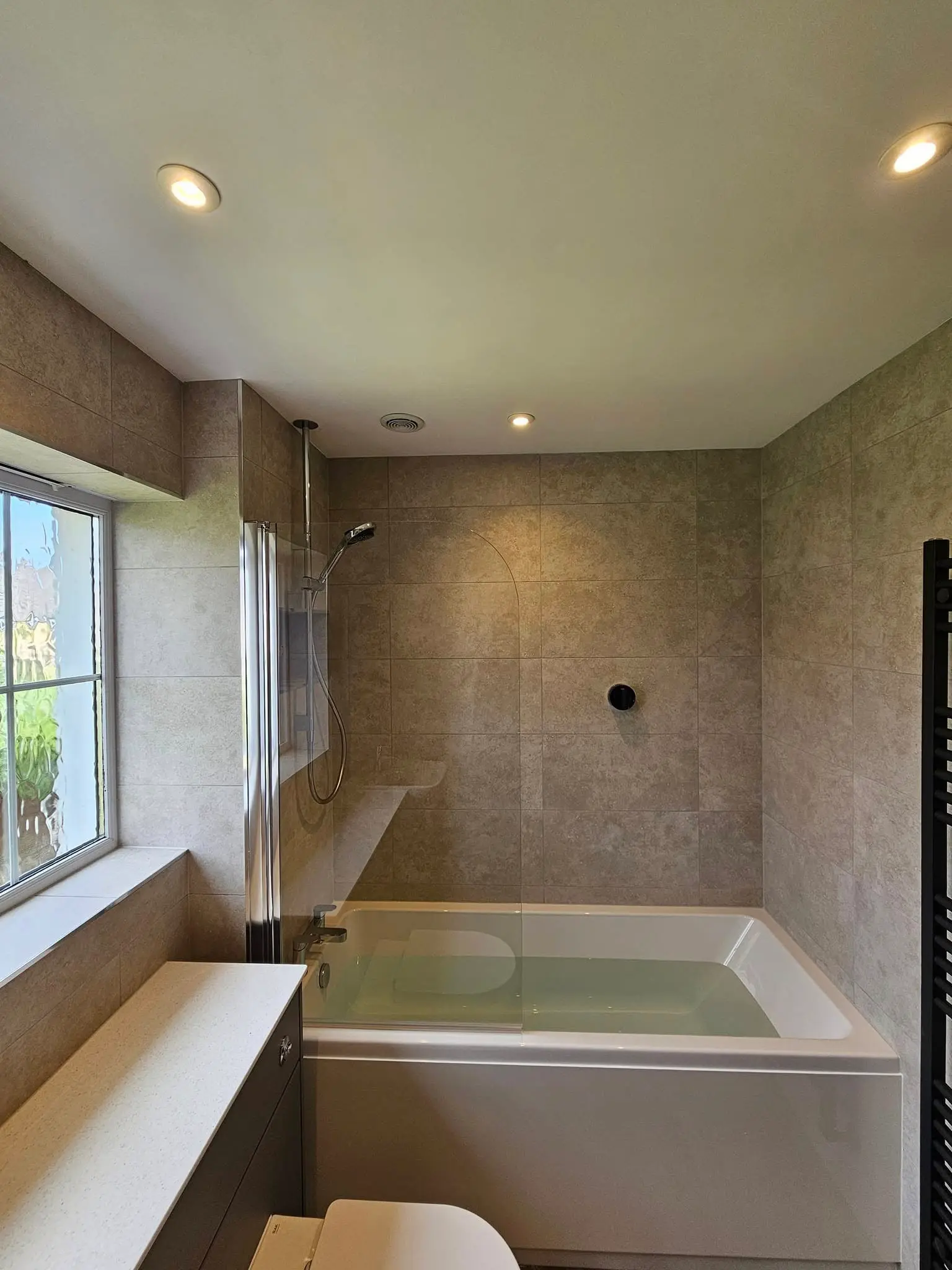 Bath surrounded by book-matched marble panels